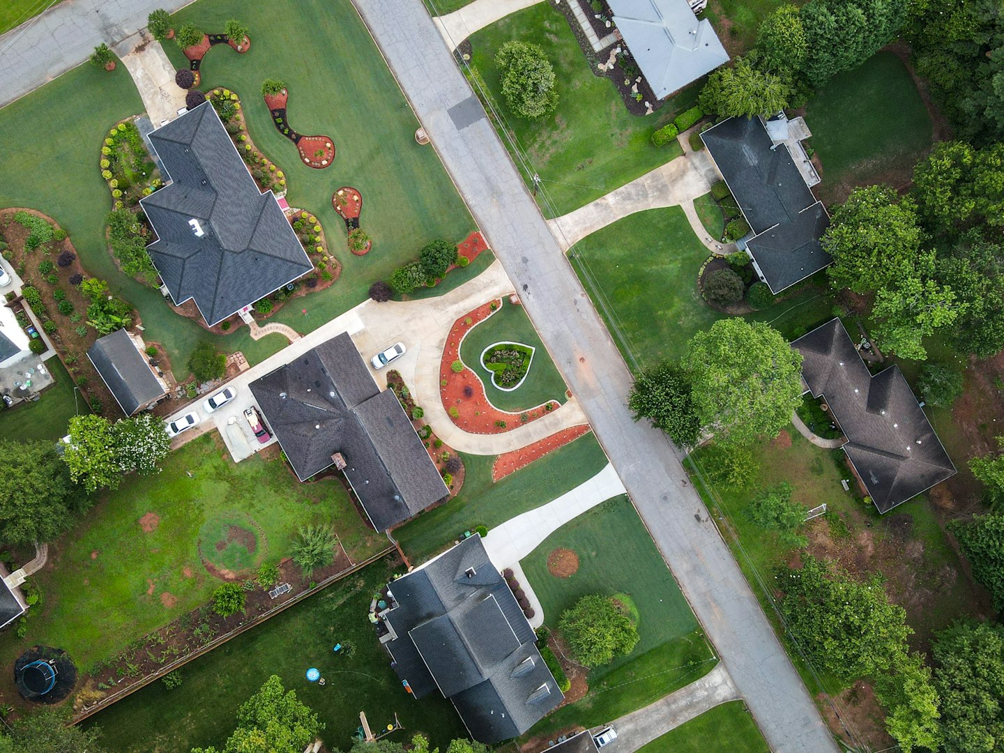 Houses with green lawns and driveways in a suburban neighborhood.