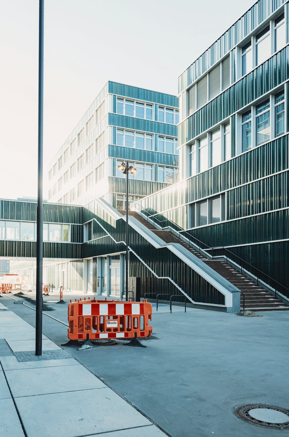 Modern corporate campus with striped buildings and outdoor staircase.